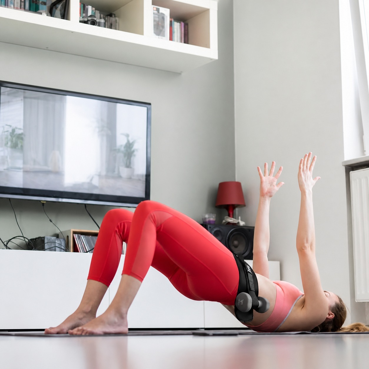 Exercise belt securing dumbbells during a glute bridge