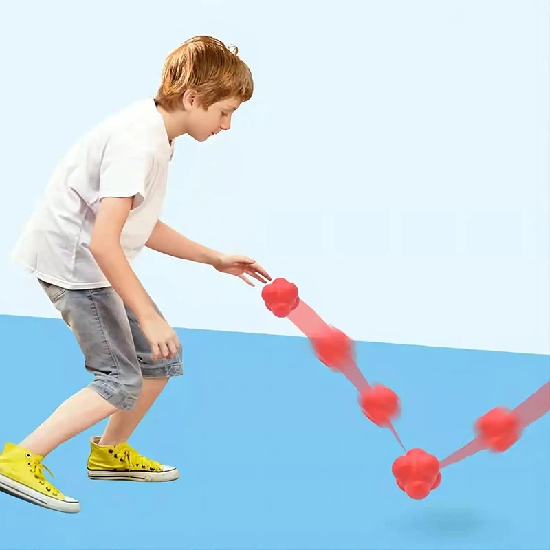 Child practising reflexes with a red hexagon reaction ball