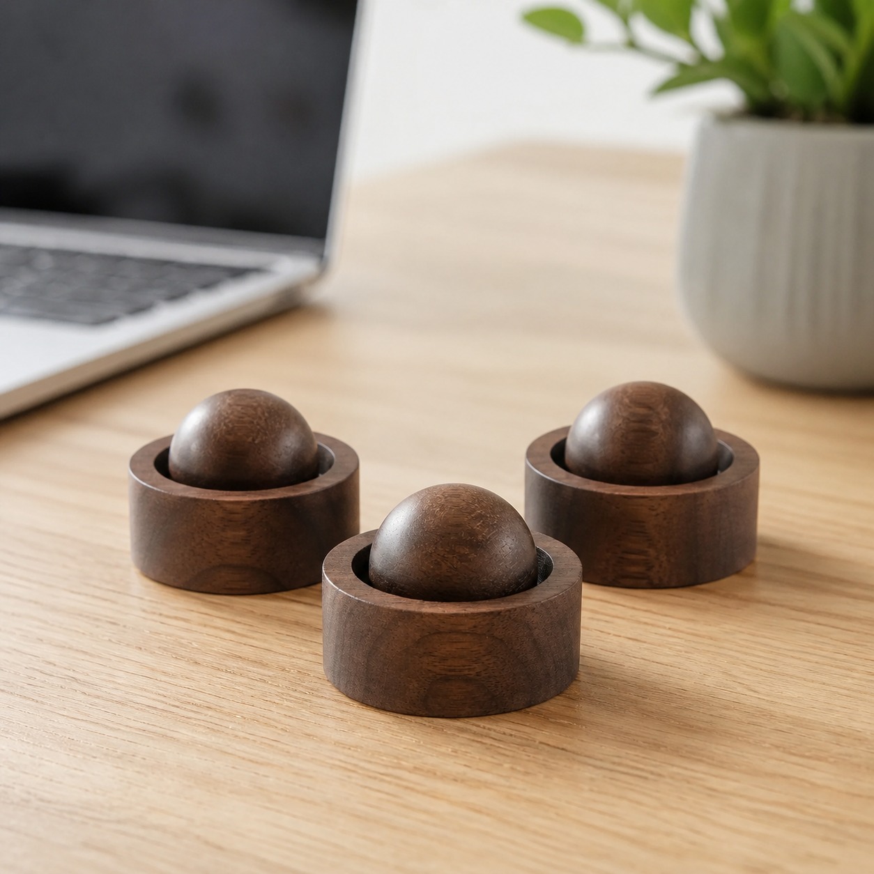 Three dark walnut wooden aroma diffusers on a home-office desk