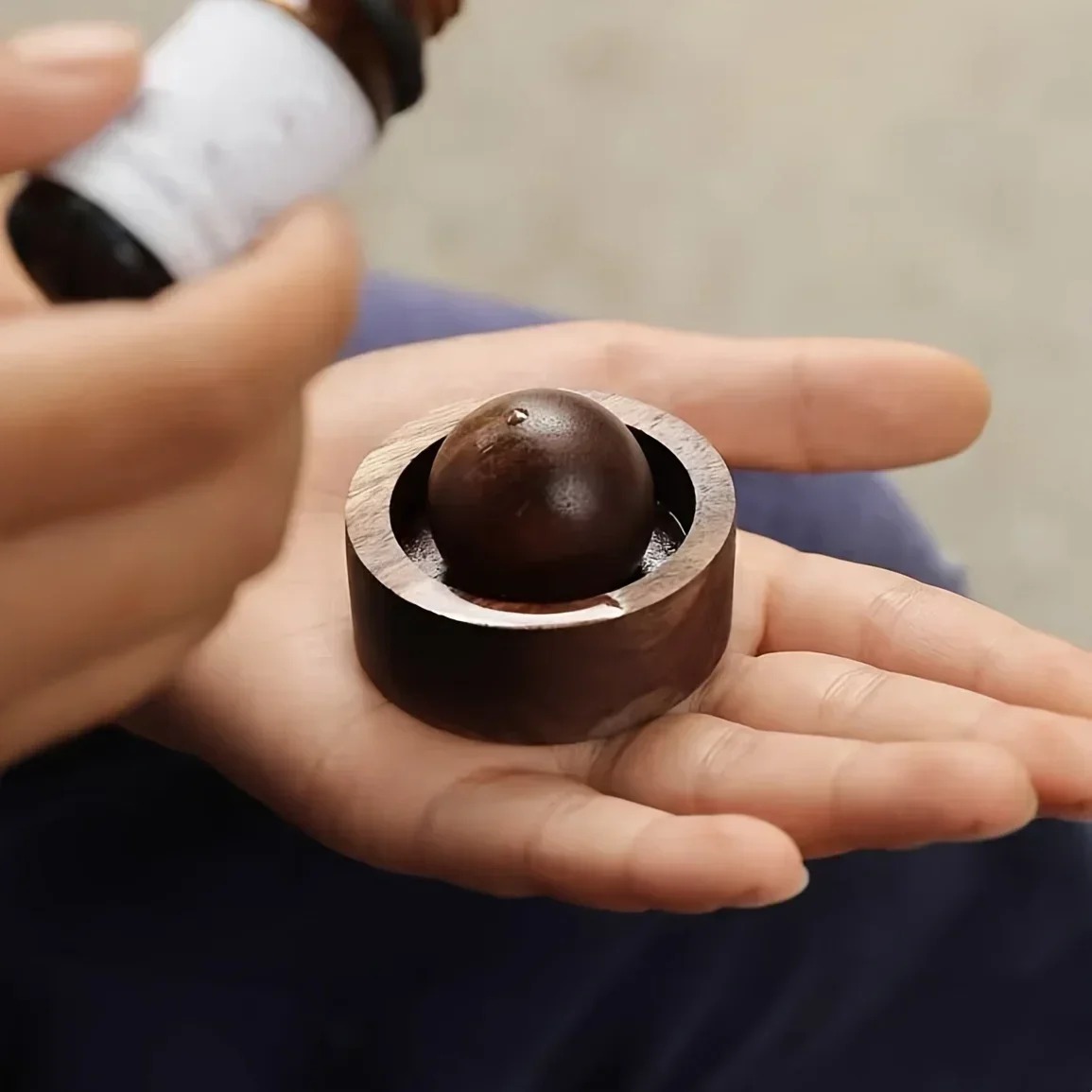 Compact dark wooden aroma diffuser held in one hand