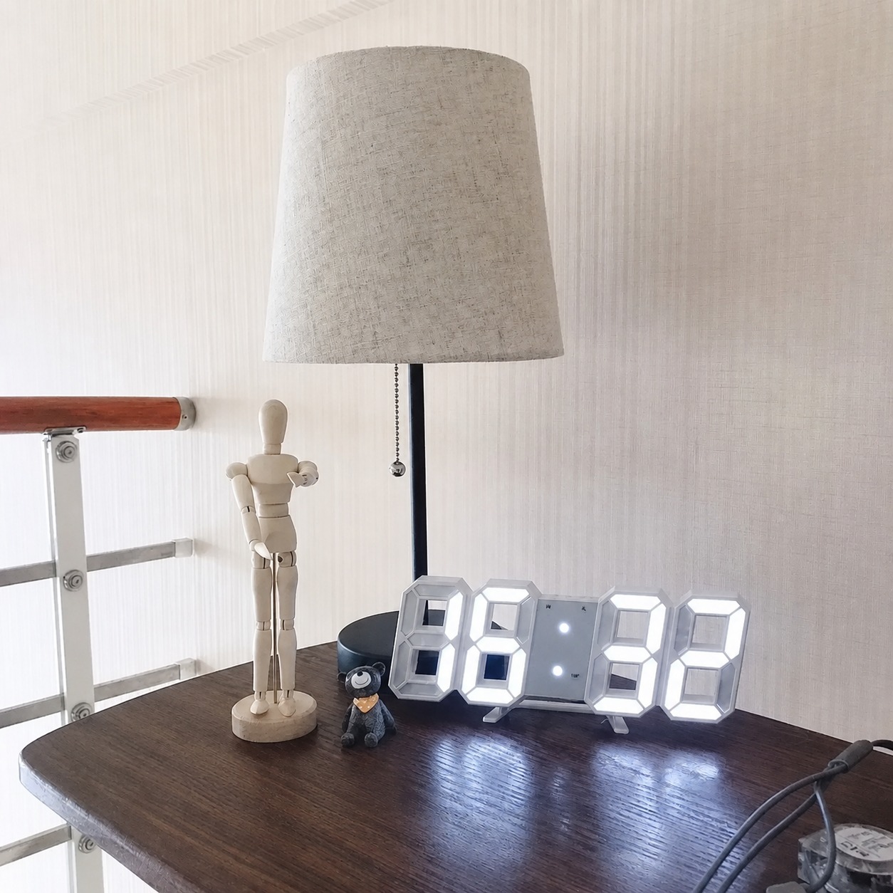 LED digital clock displayed on a desk beside a lamp